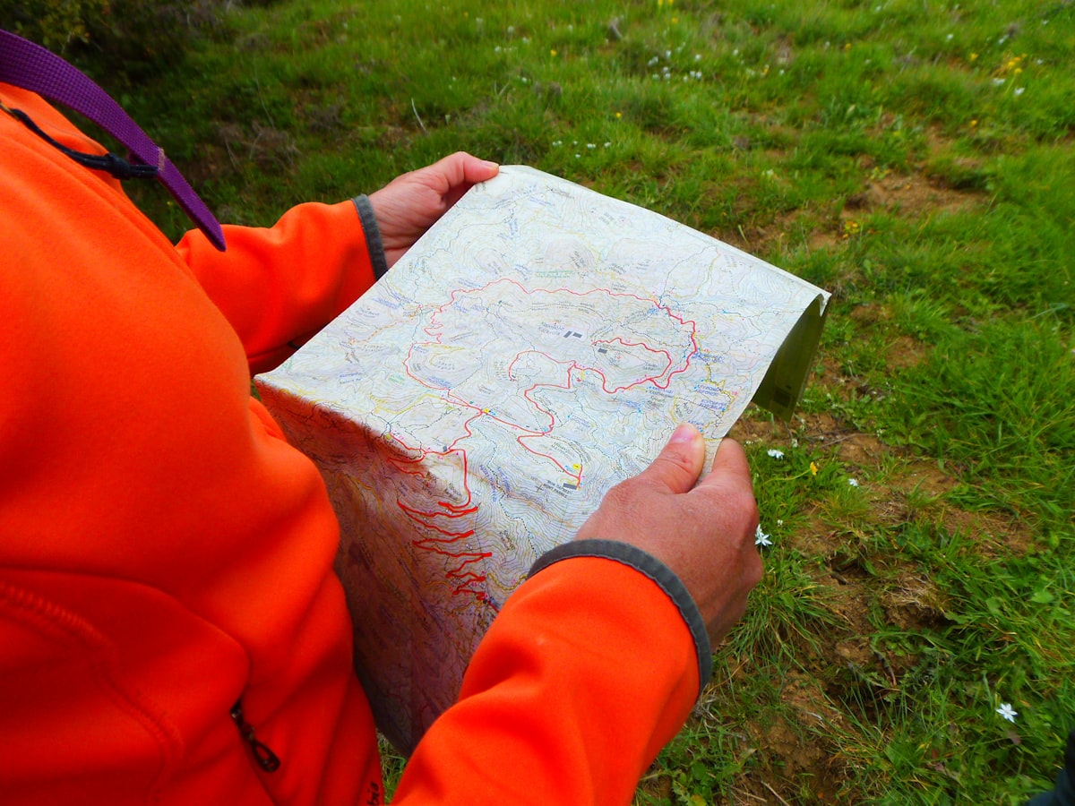 Hunter in blaze orange reviewing a topographic hunt unit map for a western elk tag application